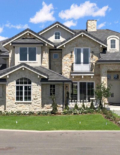 A large two-story house with stone accents and a well-manicured lawn.