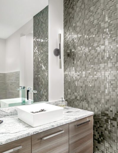 Modern bathroom with mosaic tile backsplash and floating vanity.