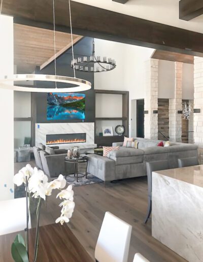 Modern living room with high ceilings, a fireplace, and contemporary furnishings.