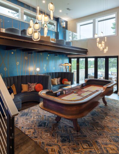 Modern living room with a piano-shaped seating area, eclectic decor, and a staircase.