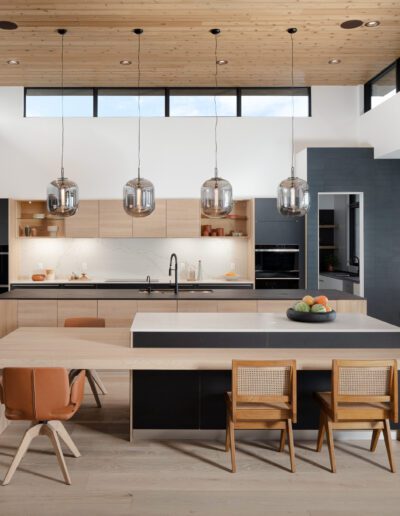 Modern kitchen with wooden ceiling, large island, and pendant lighting.