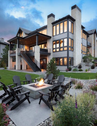 Luxury home at dusk with outdoor patio and fire pit.