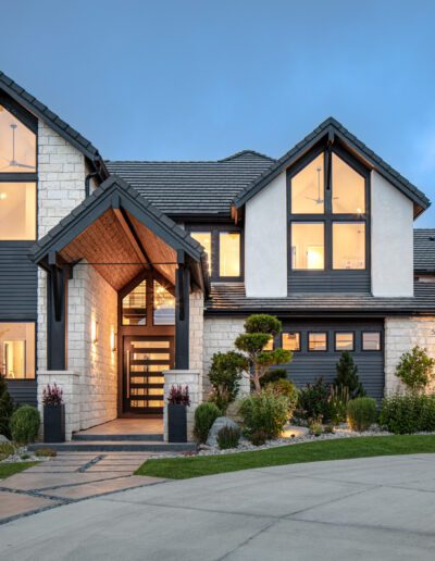 Modern two-story house with illuminated windows at twilight.