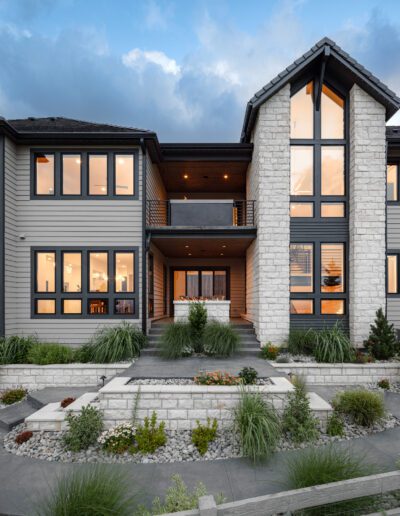 Modern two-story house with large windows at dusk.